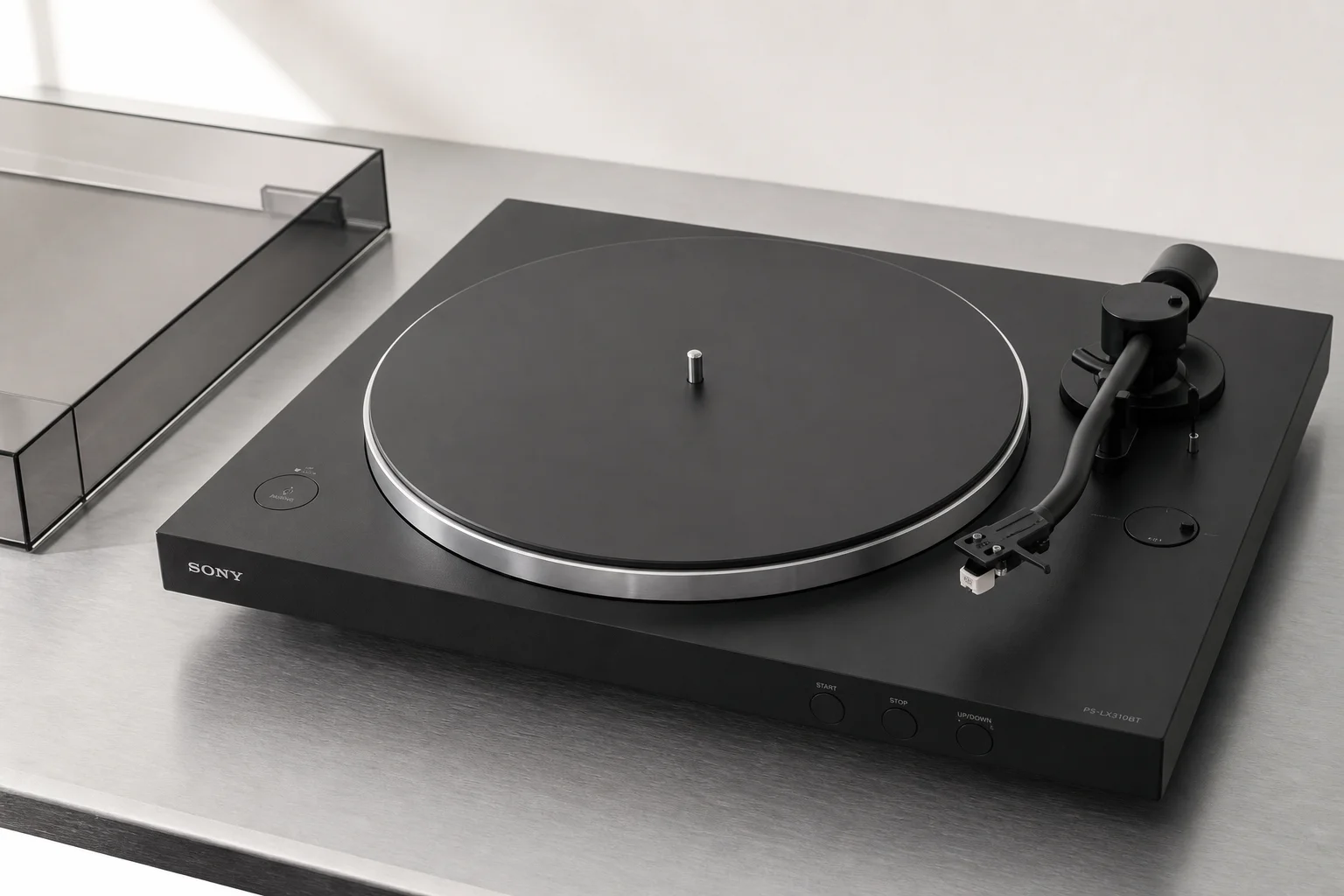 Five vinyl turntables arranged by price tier on concrete surface