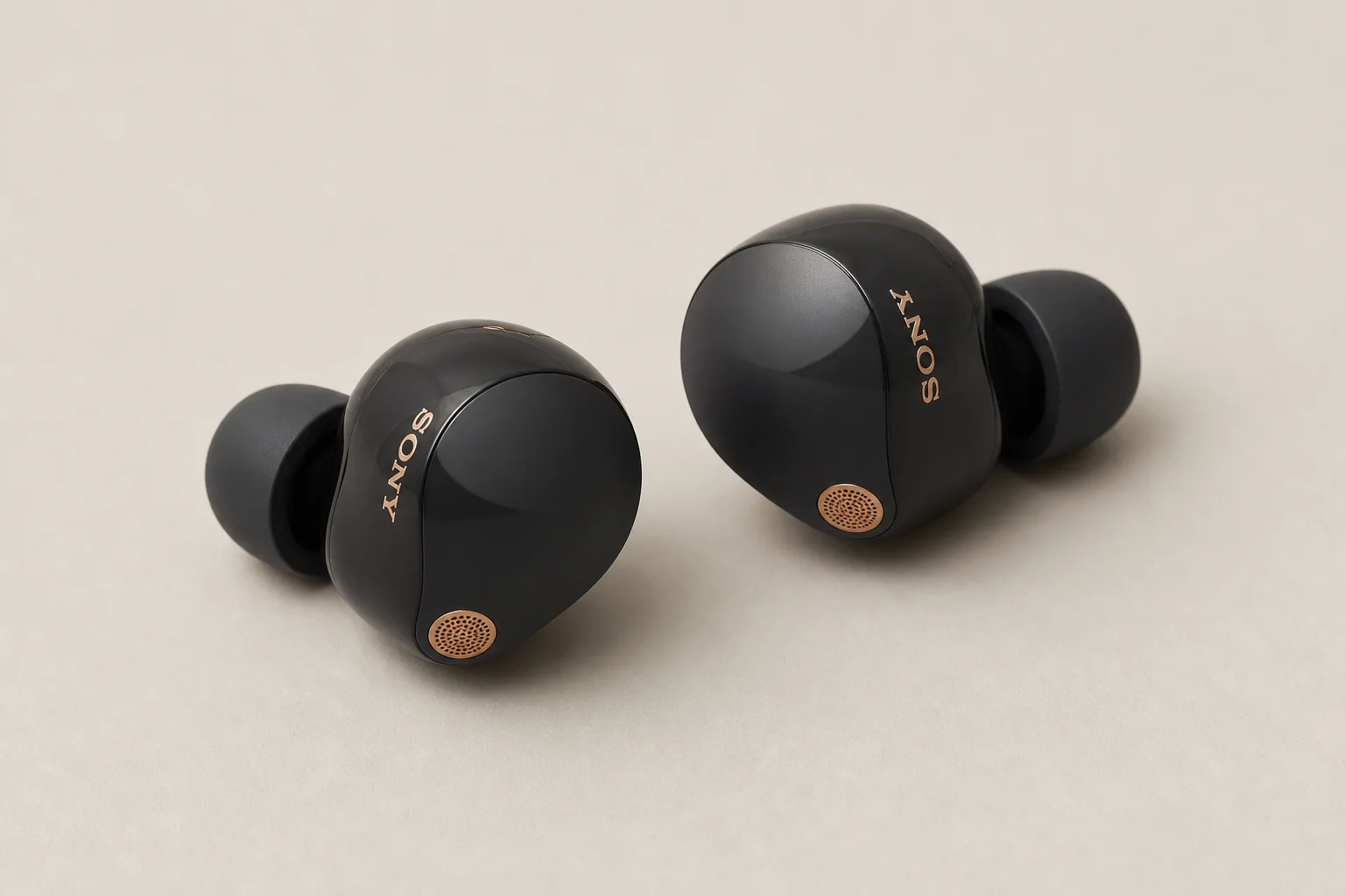 Collection of 12 true wireless earbuds arranged on concrete surface