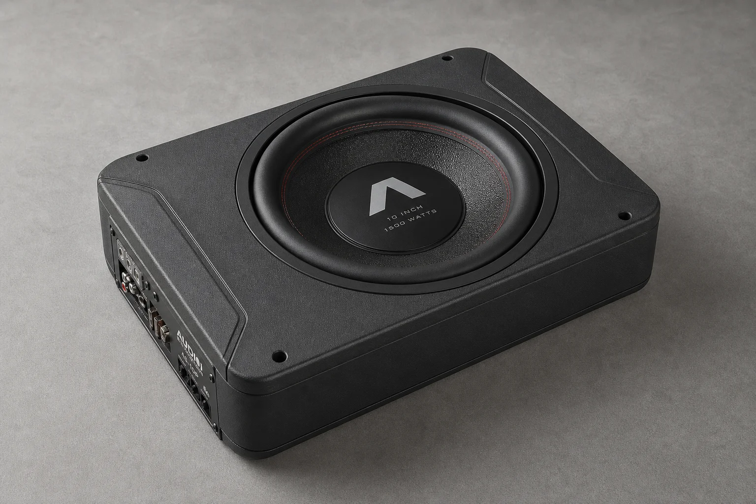 Six underseat subwoofers of varying sizes arranged on concrete surface