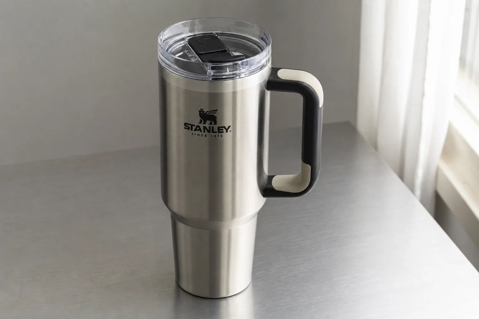 Five travel mugs arranged in ranking order on a concrete surface