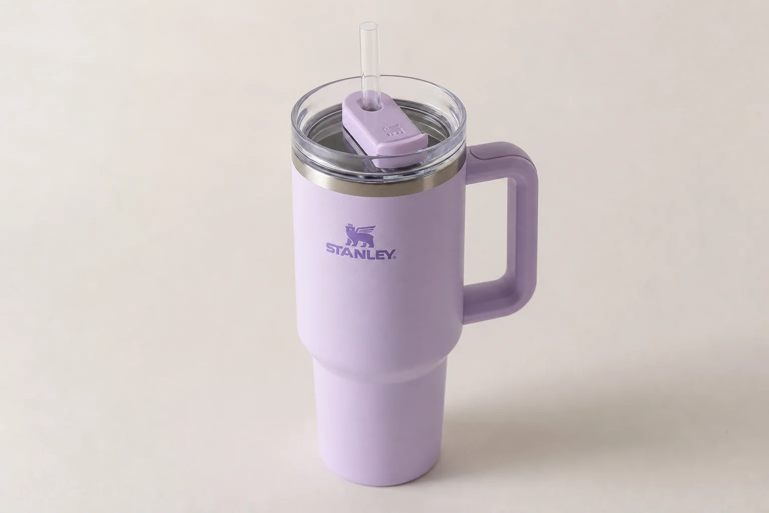 Six insulated water bottles from different brands arranged on concrete surface