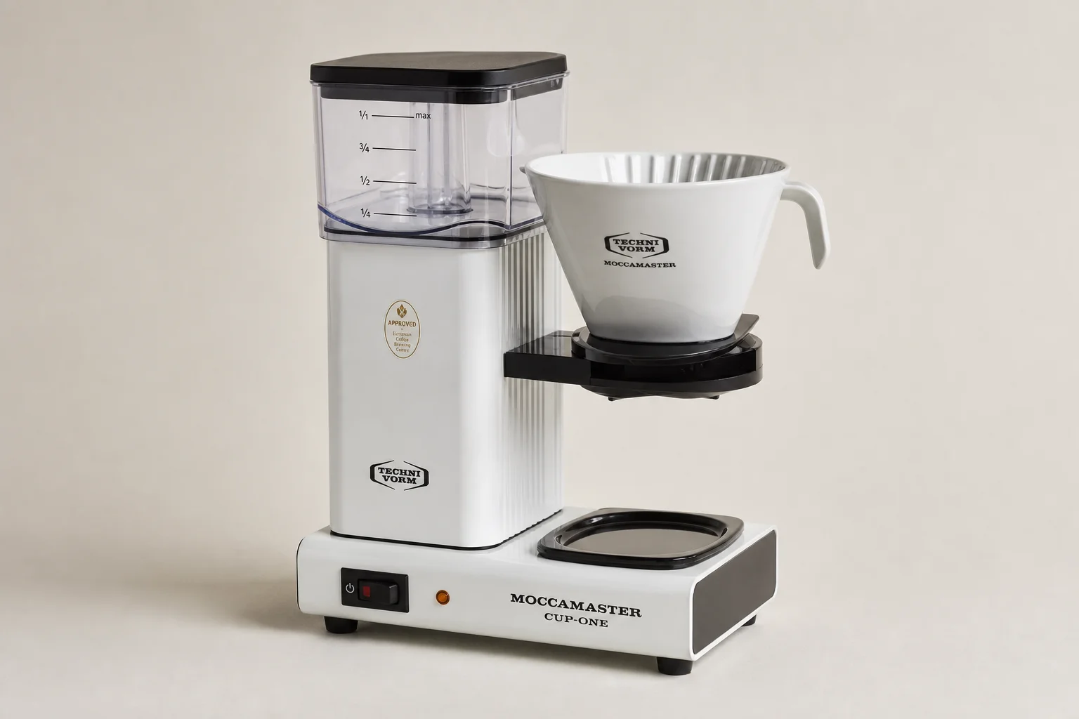 Four Technivorm Moccamaster coffee brewers arranged in a line on neutral backdrop