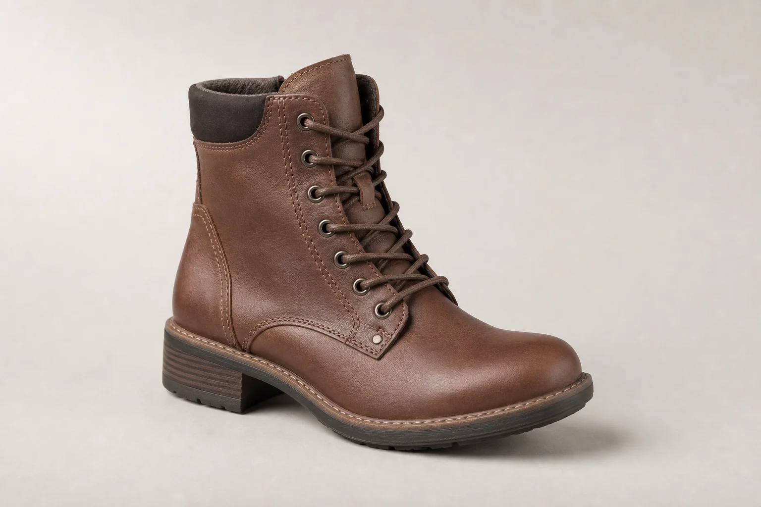 Collection of diverse winter boots arranged on concrete surface