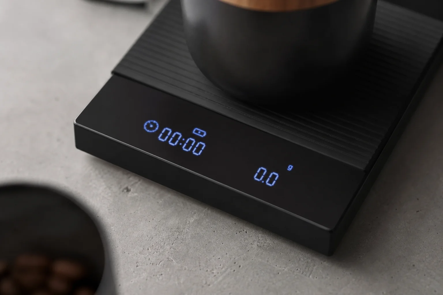 明るい青色のLED数字とタイマーが表示されたコーヒー用スケールのディスプレイのクローズアップ