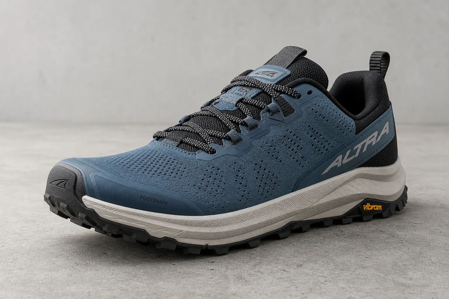 Three wide toe box trail running shoes on concrete surface