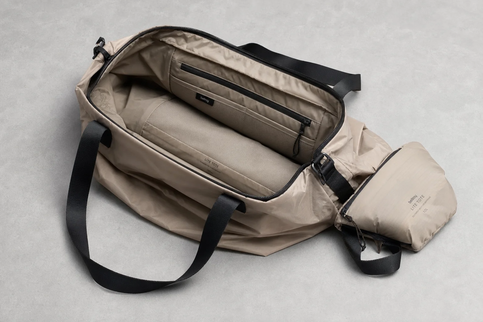 Flat-lay arrangement of 12 essential travel items on grey concrete surface