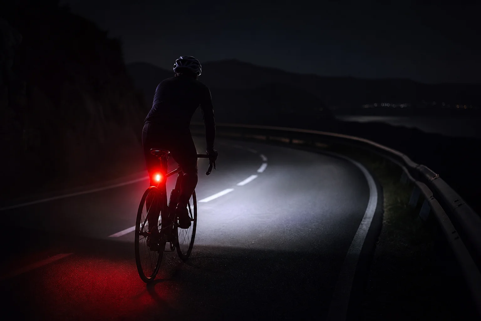 Cyclist at night with coordinated headlight and tail light system active