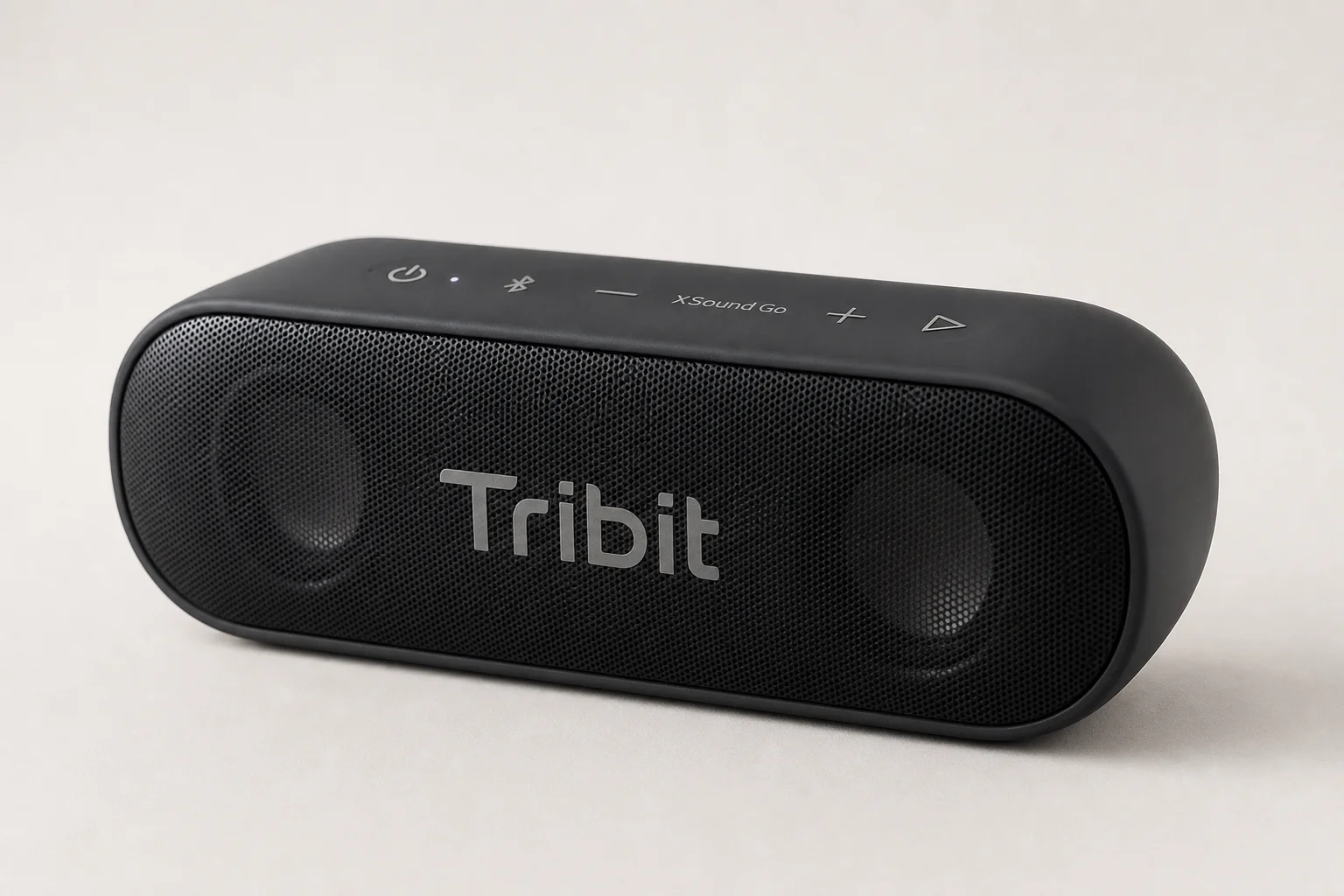 Five budget Bluetooth speakers arranged on concrete surface