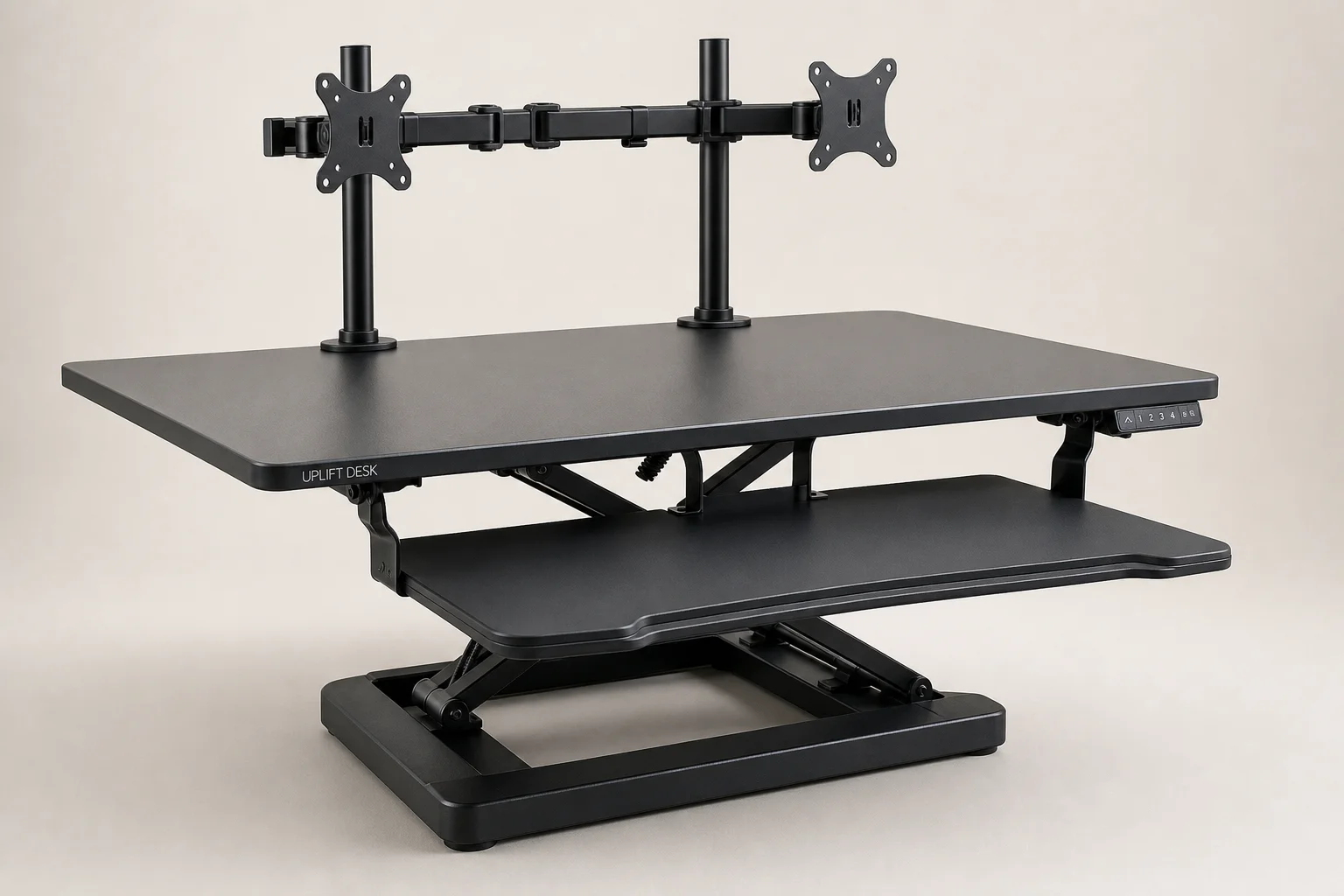 Three standing desk converters displayed on a light wood desk surface