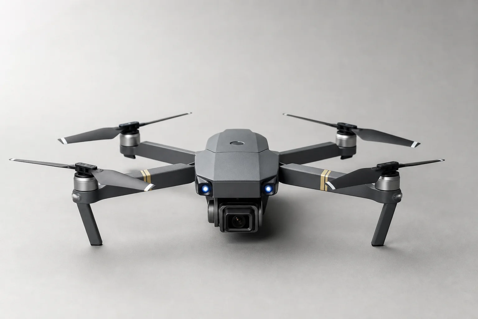 Five budget camera drones in various designs and colors arranged on concrete