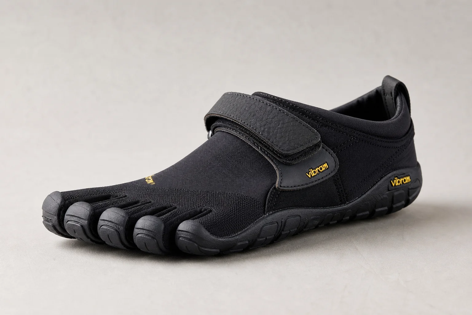 Seven barefoot shoe styles arranged on concrete surface