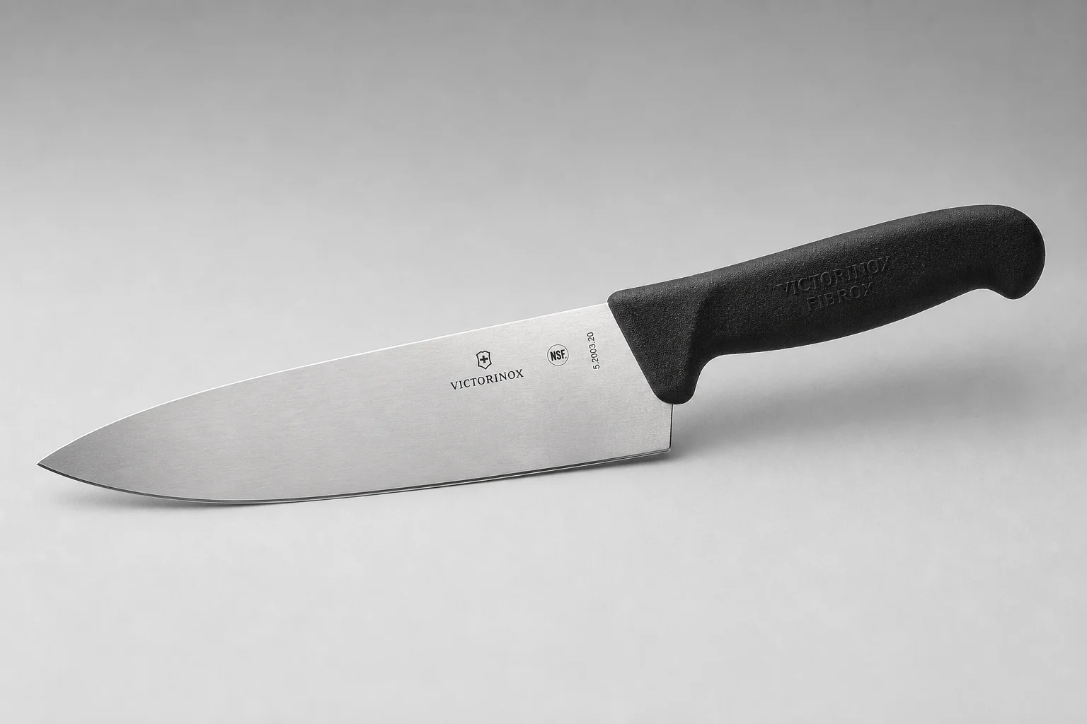 Two 8-inch chef's knives on a wooden cutting board