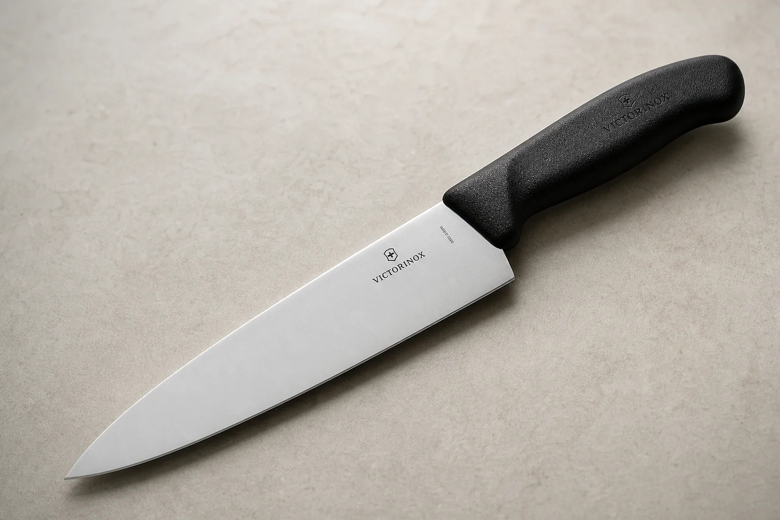 Collection of eight chef's knives arranged diagonally on concrete surface showing various styles and price points