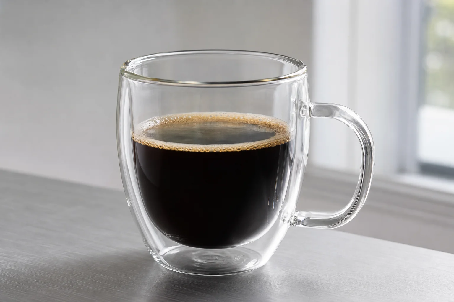 Four non-toxic coffee mugs in glass, ceramic, and stainless steel arranged on concrete