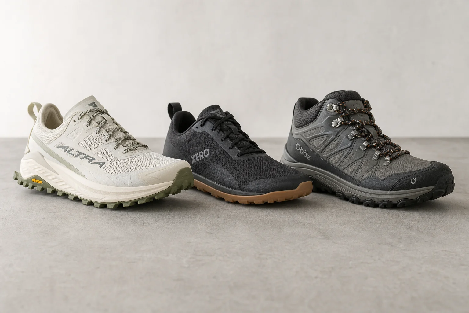 Three wide toe box trail running shoes on concrete surface