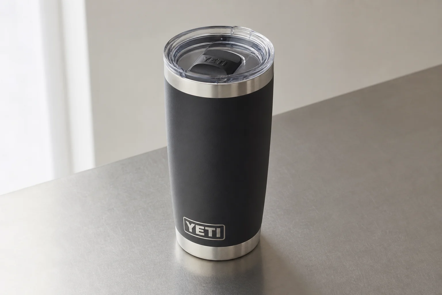 Nine 個不同款式與顏色的 YETI 絕緣隨行杯排列在水泥地面上
