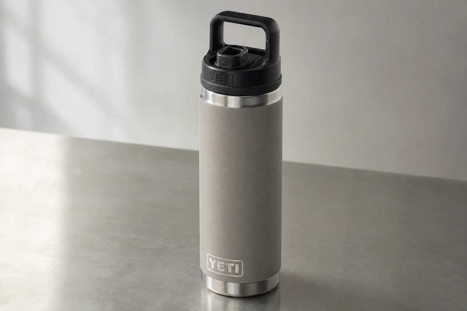 Six insulated water bottles from different brands arranged on concrete surface