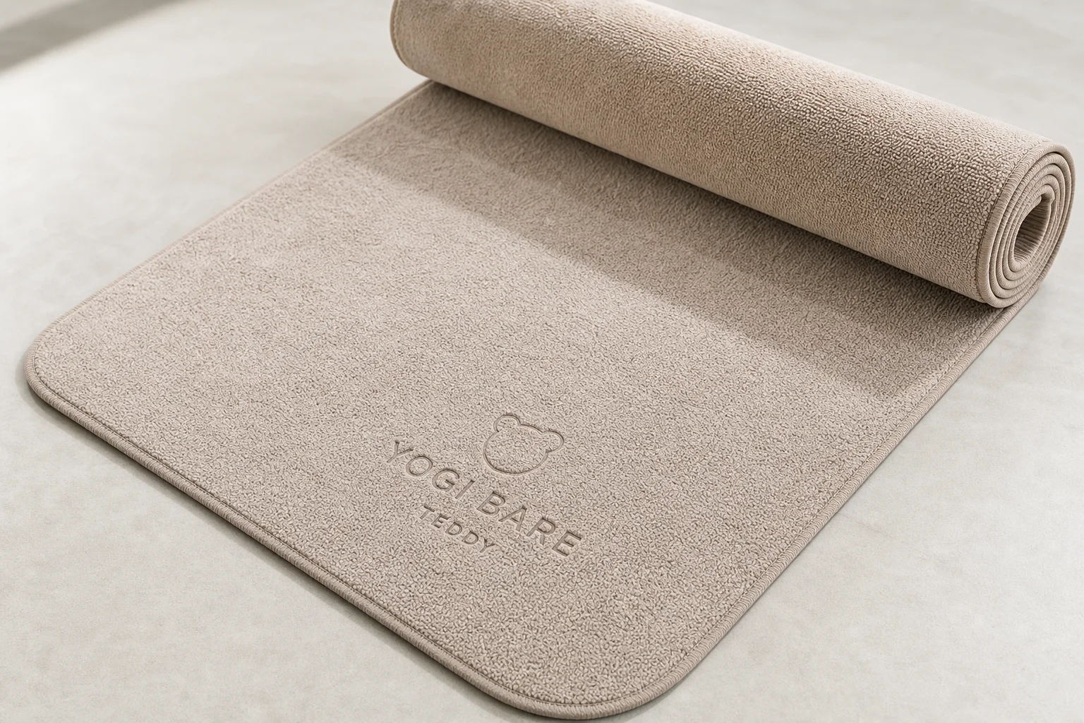 Seven different yoga mats arranged on a wooden floor showing variety of styles and colors